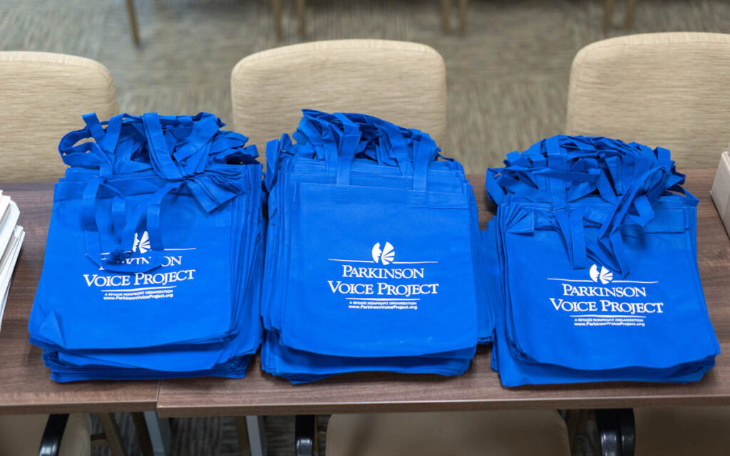 A photo of some bags with the Parkinson Voice Project logo on them